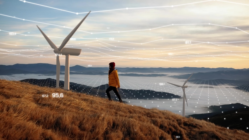 Epic shot of a woman hiking on the edge of the mountain against landscape with wind turbine power station on background. Concept of: environmental engineering, renewable energy and love for nature Royalty-Free Stock Footage #1061185285