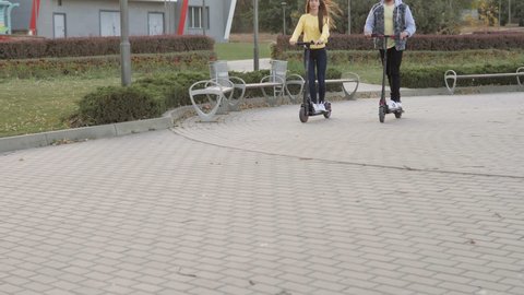 Happy couple riding on gyrocooter outdoors at the autumn city park