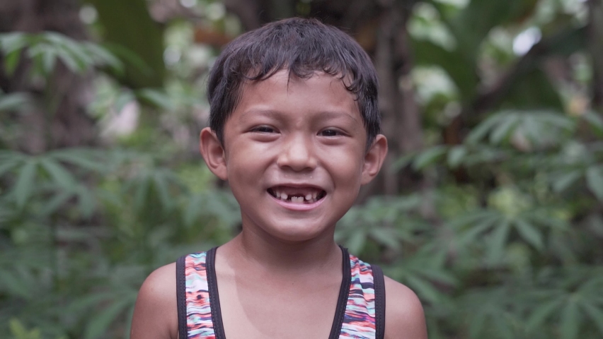 Close Up Slow Motion Video Portrait of a Handsome Cute Toothless Asian Filipino Kid Smiling into the Camera from the Rural Village in the Philippines with Extreme Happiness | Shutterstock HD Video #1061193202