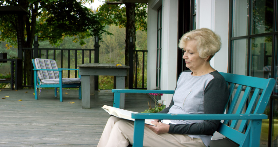 Elderly matue Caucasian husband joins his wife on a terrace of a house. Shot on RED cinema camera with 2x Anamorphic lens