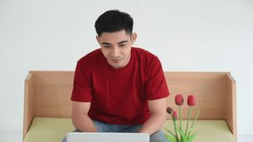 Young Asian man wear braces in casual outfit using laptop for video call or facetime with dentist and explaining toothache