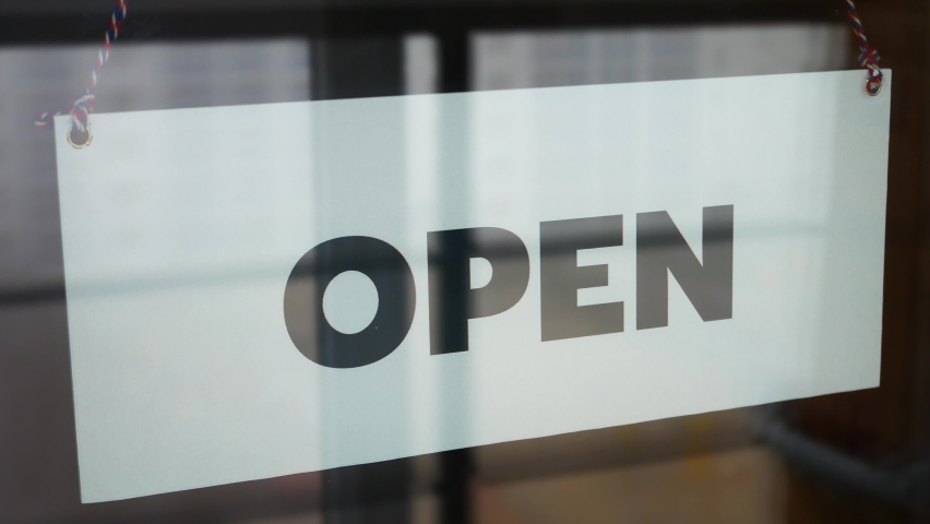 A business owner changes the sign on the front door with the inscription OPEN to the CLOSED due to COVID-19 close-up Royalty-Free Stock Footage #1061203270
