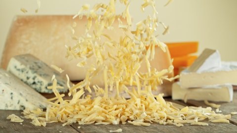 Super Slow Motion Shot of Grated Cheese Falling on Wooden Board at 1000 fps.