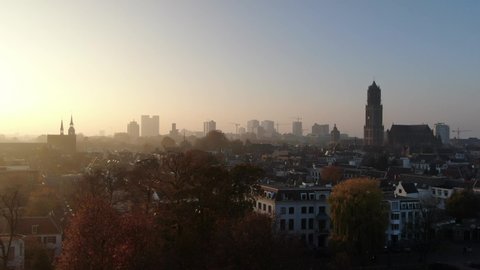 Cinematic 4k aerial video of historic Utrecht city center with the Dom Church with foggy golden light and fall colours