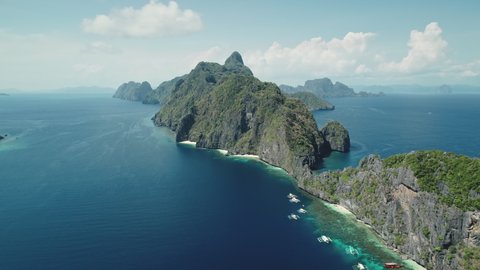 Aerial view of mount island at tropic sea coast. Panorama blue water of ocean bay with green jungle trees at hill ranges. Amazing landscape of Palawan islet, Philippines, Asia. Paradise summer tourism