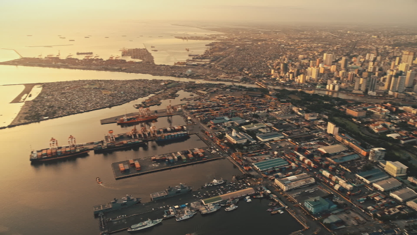 Sunrise light at sea bay town with buildings, roads aerial birds-eye view. Urban scenery of downtown district at marina with ships, boats, yachts. Highway traffic at city streets of Manila, Philippine