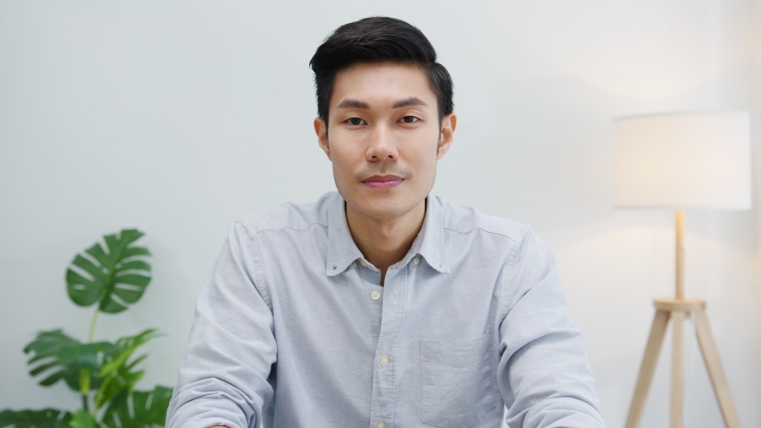 Portrait of successful handsome executive businessman smart casual wear looking at camera and smiling, happy in modern office workplace. Young Asia guy talk to colleague in video call meeting at home. | Shutterstock HD Video #1061213377