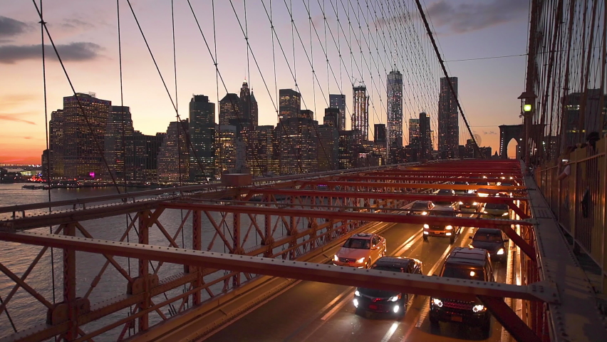 The view of the Financial District in New York City behind traffic on the Brooklyn Bridge.