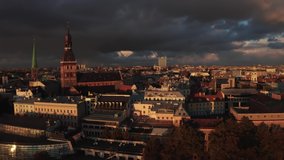 Absolutely amazing aerial shot over Riga old town, the capital of Latvia during sunny rain with a rainbow and rain clouds shining through sunlight. Beautiful Latvia. Amazing Riga scene video.