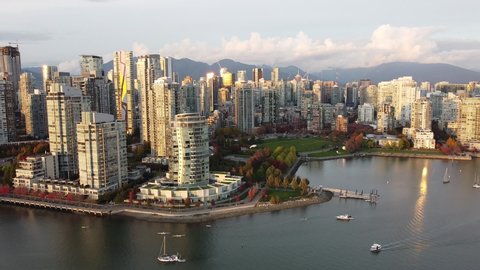 Aerial shot of Vancouver downtown in a golden evening light with red green trees