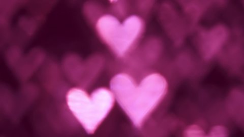 Glowing blur heart shaped lights sparkling on soft pink background. Romantic Valentine's day background.