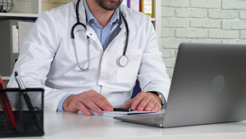 Remote doctor wears white medical coat wireless earphones consults patient  | Shutterstock HD Video #1061229316