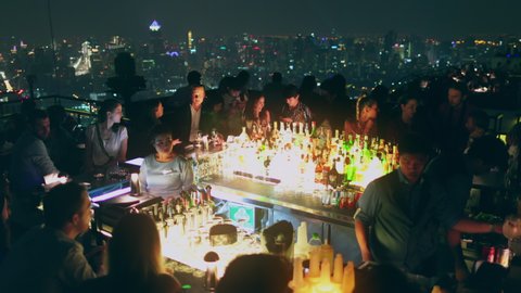 Thailand, people celebrate: roof pub with epic views of Bangkok at night. Neon lights in dark. Vertigo Rooftop and Moon Bar at Banyan Tree, 2018.02.03. Cinematic footage shot in 4k, UHD