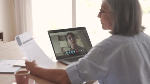 Senior woman recruiter talking to seeker during social distance job interview by video call. Elderly hr hiring female applicant communicating in conference virtual chat videocall meeting on laptop.