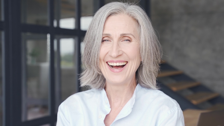 Smiling mature grey-haired business woman laughing in office. Happy confident middle aged lady, attractive senior female professional coach, older executive leader close up face headshot portrait. | Shutterstock HD Video #1061232400