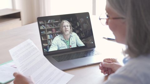 Senior business woman distance teacher giving online class for student. Business woman talking with client, colleague, in video conference call virtual chat meeting on laptop working from home office.