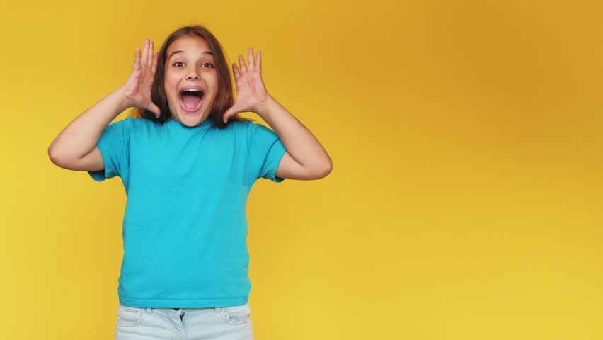 Impressed child. Perfect surprise. Exciting news. Wow reaction. Portrait of happy amazed astonished young girl in blue t-shirt celebrating victory isolated on yellow copy space background. Royalty-Free Stock Footage #1061234374