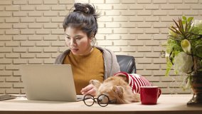 Asian female woman using laptop computer online meeting work at home while her dog sleep nearby on working table. Work at home lifestyle isolate working quarantine period new normal concept