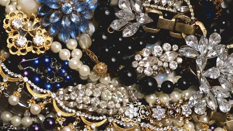 Jewelry. Rotating seamless loop background from many beautiful female fashion jewel with precious shiny stones, pearls and diamonds for women. Wealth and luxury concept, closeup, macro. Loop motion