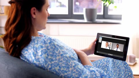 pregnancy, technology and medicine concept - happy pregnant woman with tablet pc computer having video call with doctors at home