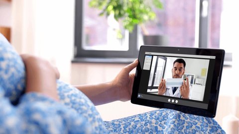 pregnancy, technology and medicine concept - happy pregnant woman with tablet pc computer having video call with doctor showing medical mask at home