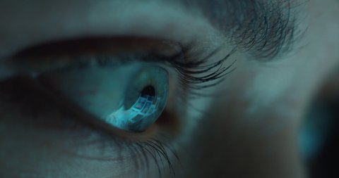 macro eye looking at tablet screen browsing social media at night addiction concept