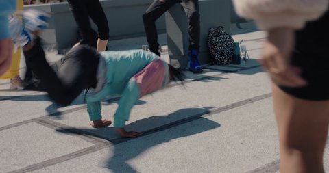 man breakdancing on rooftop at hip hop dance party performing crazy breakdance moves with friends dancing and celebrating