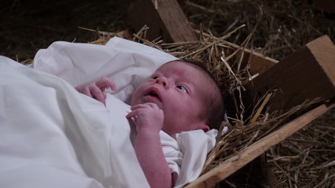 4K Gimbal: Baby Jesus laying in a Manger with straw and Hay. Christmas Nativity Scene in the stable. Side View