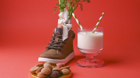 hildrens shoe with carrots for Santa's horse, milk, pepernoten and sweets on a bright background. Dutch holiday Sinterklaas. Stop mo.