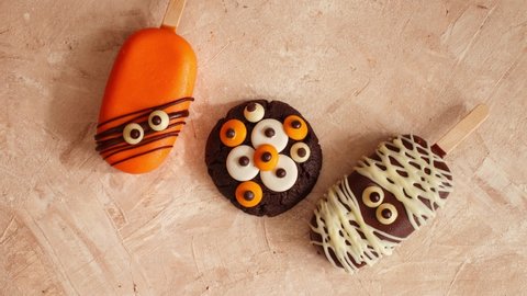 Halloween cooking recipes. Сhocolate chip cookies decorated with chocolate eyes. Festive Halloween cookie. Delicious spooky halloween baking. Stop motion animation, top view