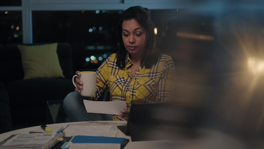 Multiethnic woman doing budget and counting money at home, girl checking dollars to pay utilities bill late at night. Young latin people reviewing invoice, planning family business and filing taxes Royalty-Free Stock Footage #1061254633