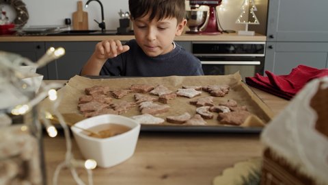 Video of little boy stealing gingerbread cookies from the table. Shot with RED helium camera in 8K.