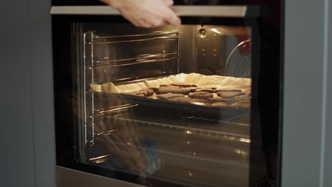 Video of woman taking out homemade gingerbread cookies from the oven. Shot with RED helium camera in 8K.