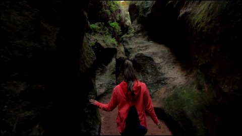 cave exploration, exploring a cavern. Young explorer walks through a narrow path in caves and caverns in Estrecho de la Arboleja or Agualeja in Murcia, Spain.