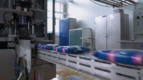 Automated industrial line at modern dairy food production factory. Milk is sorted into plastic packages and got stamped automatically one by one. Advanced dairy products manufactire plant