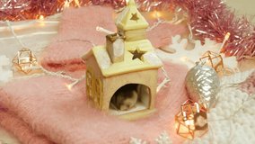 Little mouse washing face in his new year house on pink background of christmas lights
