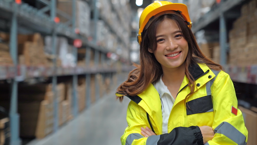Portrait of Asian female staff smiling while standing in warehouse. Distribution storage area about logistics and organization , industrial workers concept. Royalty-Free Stock Footage #1061270131