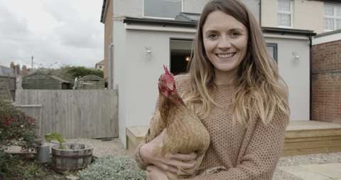 Woman holding Hen Chicken and let loose in Garden at home, simple living Stock video