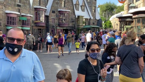 Orlando, FL/USA - 10/18/20:  People walking through the Wizarding World of Harry Potter's Hogsmeade wearing face masks at Universal Studios.