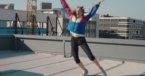 funny woman dancing on rooftop celebrating enjoying silly dance having fun crazy dancer generation z in city