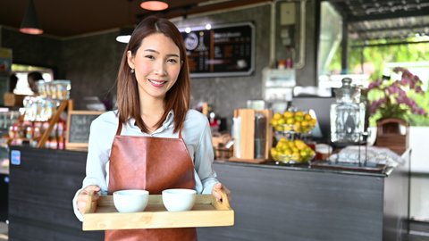 Asian female barista serving a coffee to customer. concept of start up new business 