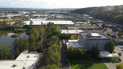 Aerial / drone footage of the warehouses, businesses and commercial area around the shopping center / mall in Tukwila, Green River Valley, Washington