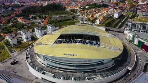 Oporto / Portugal - 09 21 2020: Aerial view around the FC Porto football stadium, Estadio de Dragao arena, revealing the cityscape of Oporto city, Portugal - tilt up, orbit, drone shot	