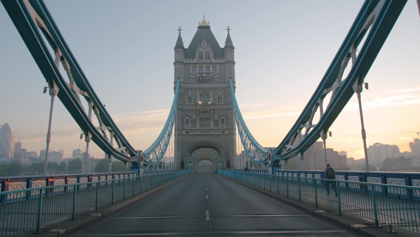 Lockdown in London, slow motion gimbal walk down Tower Bridge road during the COVID-19 pandemic 2020, with lone walker and cyclist.