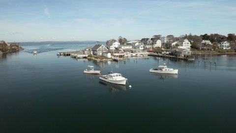 Coastal fishing village with boats in large tide pool, drone shot