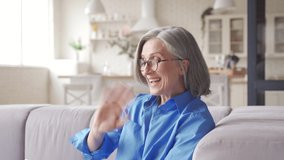 Happy old senior woman grandmother waving hand holding digital tablet video conference calling talking enjoying social distance party, virtual family online chat meeting with grandchildren at home.