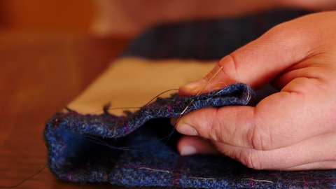 French tailor sewing creating luxury custom bespoke suit for wedding. bridal tailoring made in France with Harris tweed. mens fashion style for dapper gentleman with beautiful fabric. luxury life