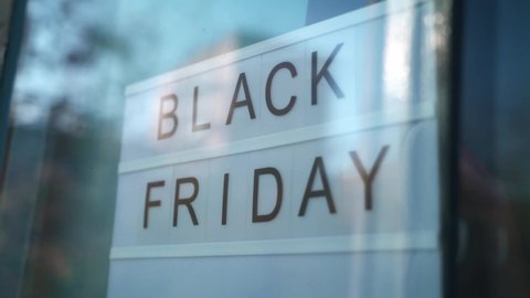 Lightbox Sign Black Friday behind a glass door of the cafe. Concept Black friday, season sales time.