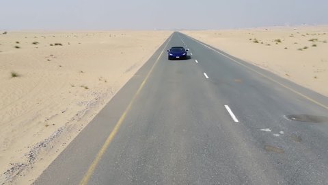 blue Lamborghini rides through the desert. Dubai al qudra desert. 2020.08.28