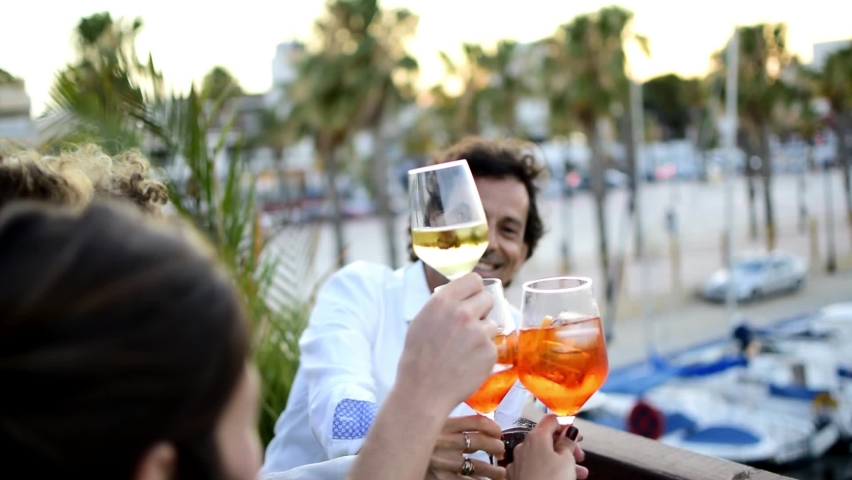 Toast toasts of friends drinking alcohol in terrace. Fun time with friends toasting or making cheers. young cheerful people chatting and drinking beer while sitting making a toast at restaurant or bar | Shutterstock HD Video #1061287492